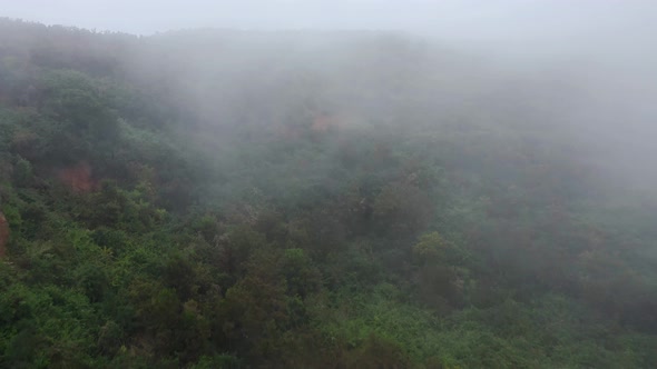 Flying Along the Slope of the Mountain at Cloud Level