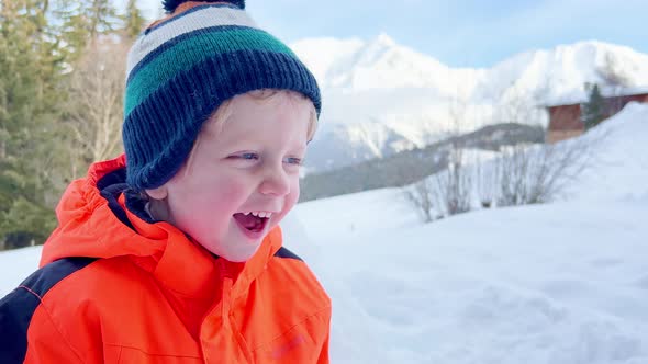 Boy in Orange Coat Play Outside on Sunny Winter Day