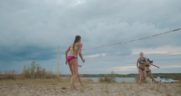 Match of Two Ladies Beach Volleyball Teams at Summer Cloudy Day, Women Are Passing, Serving Ball and