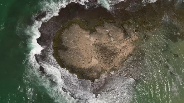 Ocean waves breaking on a rocky shore, Aerial view.