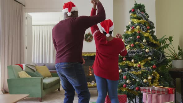 Happy senior african american couple decorating christmas tree in the living room