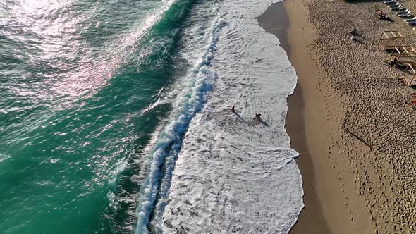 A young girl happily fights with the waves aerial view 4 K