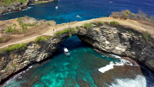 Aerial View of Tourist Speedboat at Azure Sea in Broken Beach, Nusa Penida, Bali, Indonesia. Aerial 