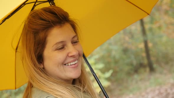 Slow motion outdoor Caucasian blond woman with yellow umbrella 1920X1080 HD footage - While raining 