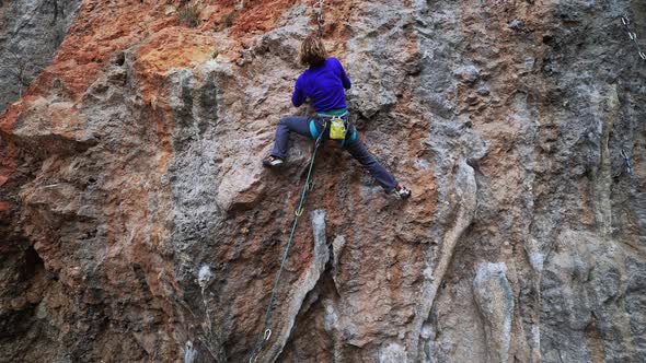 Slow Motion Footage of Strong Woman Climber Climbs Hard Overhang Route Clipping Rope to Carabiner