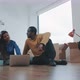 Couple in their new flat sitting on the floor shopping online for new furniture - VideoHive Item for Sale