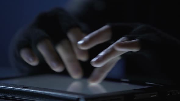 Closeup of Criminal's Hands Scrolling Pages on Tablet Touchscreen, Cybercrime