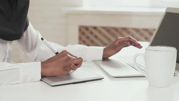 Woman Working on Digital Tablet and Laptop