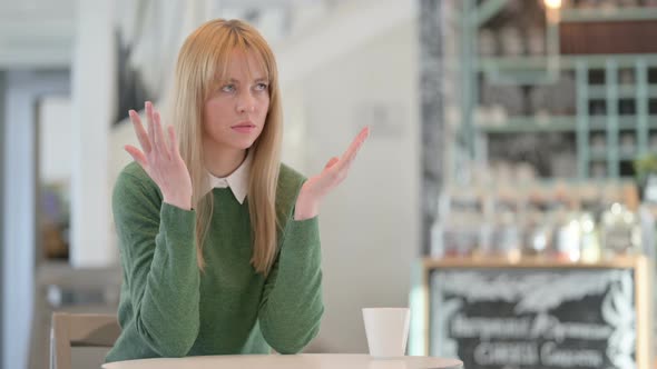 Upset Young Woman Feeling Angry While Sitting in Cafe