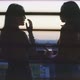 Two girls having drinks and talking on the balcony with a city view - VideoHive Item for Sale