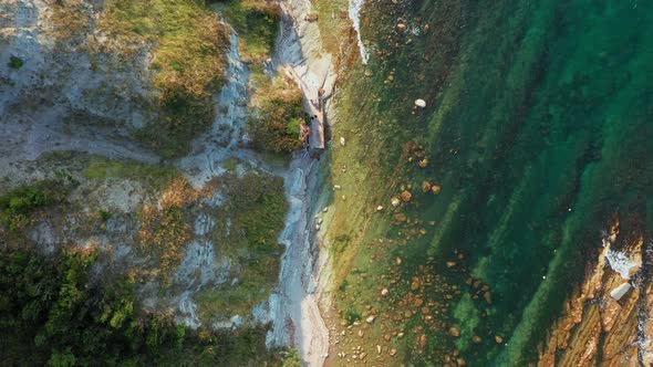 Top View of Rocky Coastline Down Blue Sea Deep White Cliffs