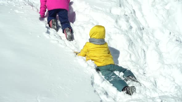 Children Climb and Flounder in Pure Snow on a Sunny Winter Day