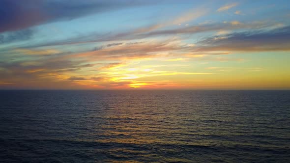 Aerial drone view of a sunset at the beach over the ocean