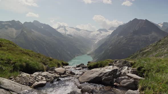 A small river in the foreground disappears on the edge of a cliff. It looks like it is flowing strai