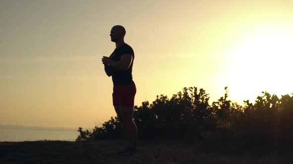 Bald Caucasian Guy Looking Focused Doing Lunges Warming Up Keeping Hands in Front of Him on Fresh