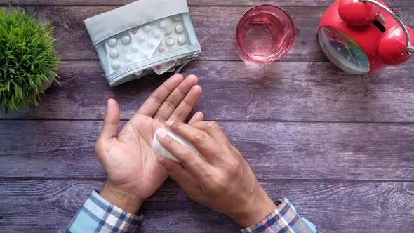 Man's Hand with Medicine Spilled Out of the Pill Container