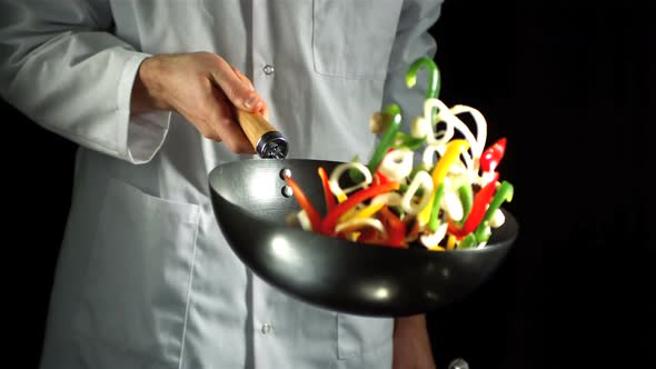 Chef tossing vegetable stir fry in wok