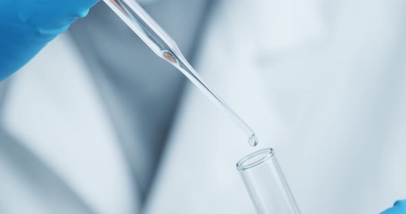 Technician Carefully Drips the Solution From the Pipette Into Glass Tubes.