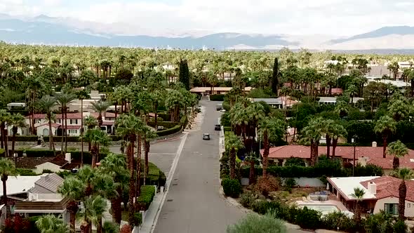 Drone shot of Palm Spring looking down to reveal the street and houses from a birds eye view.