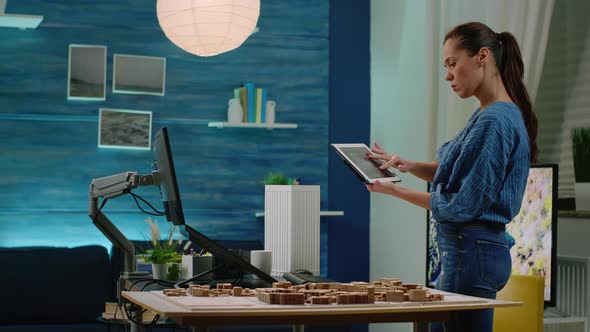 Architect Looking at Digital Tablet with Building Model