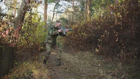 The Soldier Aims in Different Directions on Object with a Rifle Sight at Forest