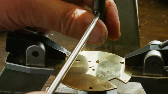 Hand of horologist using screwdriver