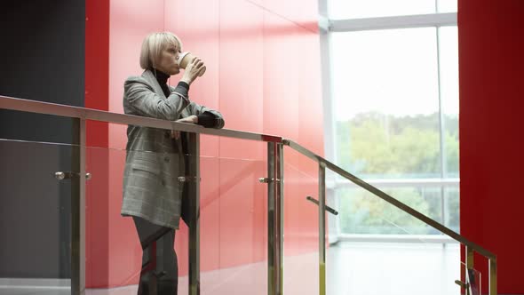 A Side View Slow Motion General Shot of a Middle-aged Business Woman Enjoying a Coffee on Her Lunch