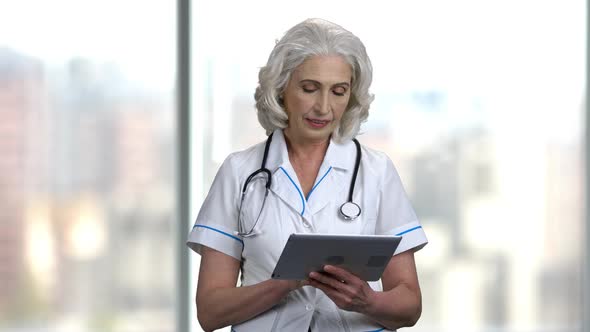 Mature Female Doctor Holding Computer Tablet.