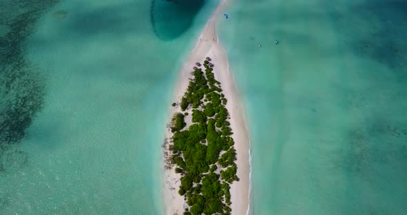 Wide angle overhead island view of a white paradise beach and blue water background in colourful 4K