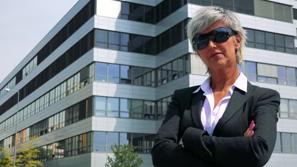 Business Middle Age Woman Puts on Sunglasses and Smiles To Camera - Company Building