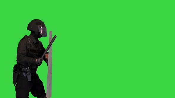 Riot Policeman with a Shield Up and a Rubber Baton Walking By on a Green Screen Chroma Key