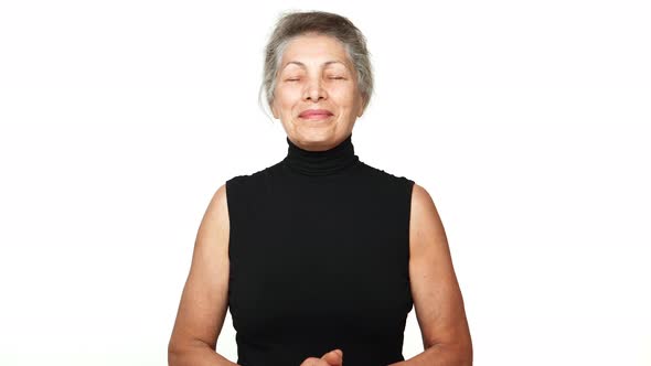 Happy Grandma with White Tied Hair Posing at Camera with Closed Eyes Thinking About Something