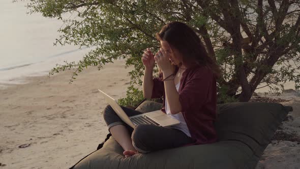 Girl Working with a Laptop on the Tropical Beach