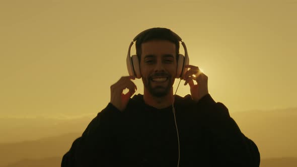 happy boy with headphones at sunset