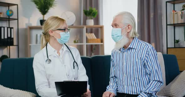 Bearded Man in Mask Talking with His Local Female Doctor and Telling About Well-Being