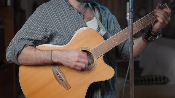 Caucasian Young Man Singing and Playing the Guitar Standing in His Living Room