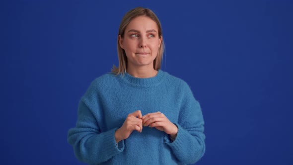 Displeased woman wearing blue sweater spreading her hands to the sides