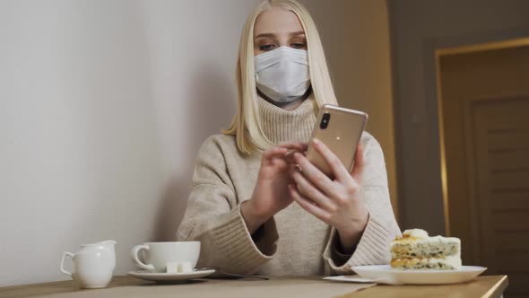 Businesswoman Working on a Laptop in a Cafe in a Medical Mask Removes