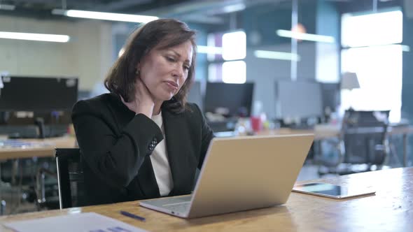 Tired Middle Aged Businesswoman Having Neck Pain at Work