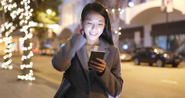 Young Woman use of smart phone in city at night