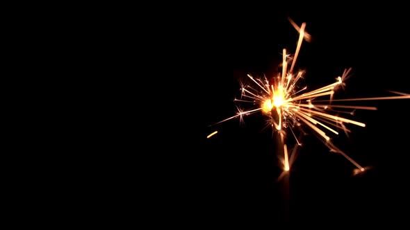 Festive Sparkler Emits Sparks on a Black Background Closeup