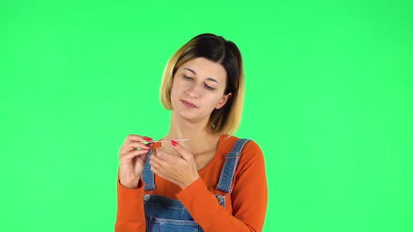Girl Makes Herself Manicure with Pink Nail File. Green Screen