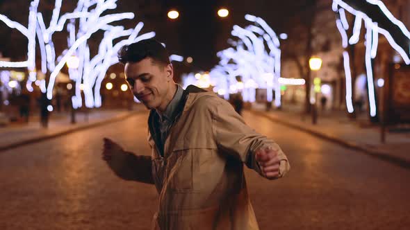 Portrait of Handsome Guy Music Lover 20s Smiling and Dancing in Slow Motion While Walking Through