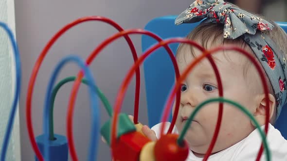 Child Plays with a Multi-colored Toy.