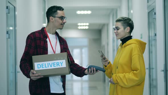 A Lady Pays By Card for a Delivery of a Parcel