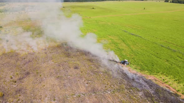 Puffs of Smoke in the Field Next to the Tractor Extinguishes the Fire