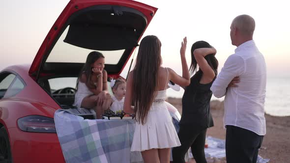 Live Camera Moves Around Relaxed Cheerful Caucasian Family Talking Resting on Picnic at Sunset