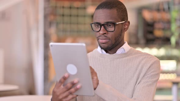 Portrait of Ambitious Young African Man Using Digital Tablet