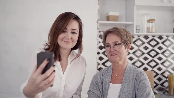 Two Woman Using Smartphone and Making Online Video Call at Home