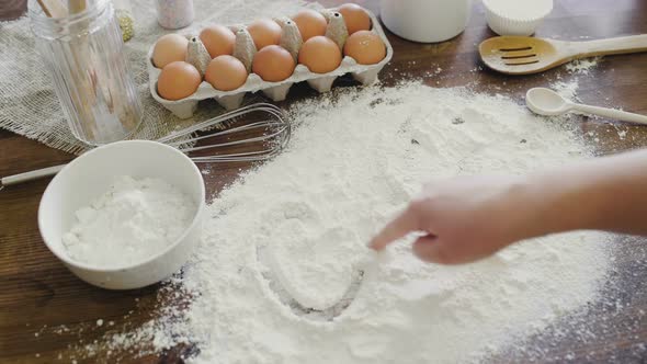 Inscription Cakes on White Flour Spills at Kitchen Table. Baking Cupcakes Concept. Home Baking